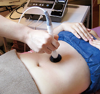 ハイパーウェーブでお腹の脂肪に施術中の女性